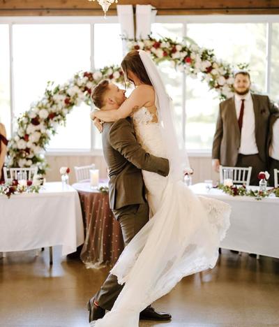 Newlywed Bride and Groom walking in a field
