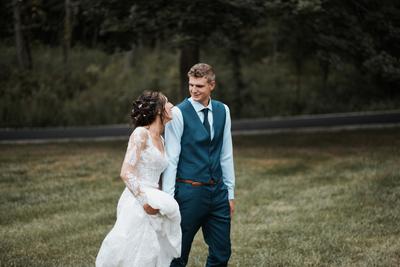 Newlywed Bride and Groom walking in a field